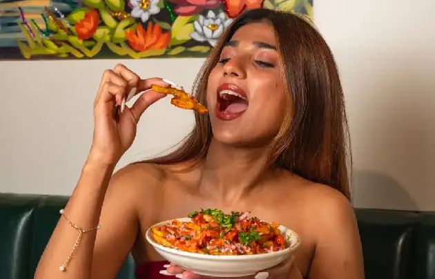 Happy woman enjoying masala french fries at Bombay Canteen