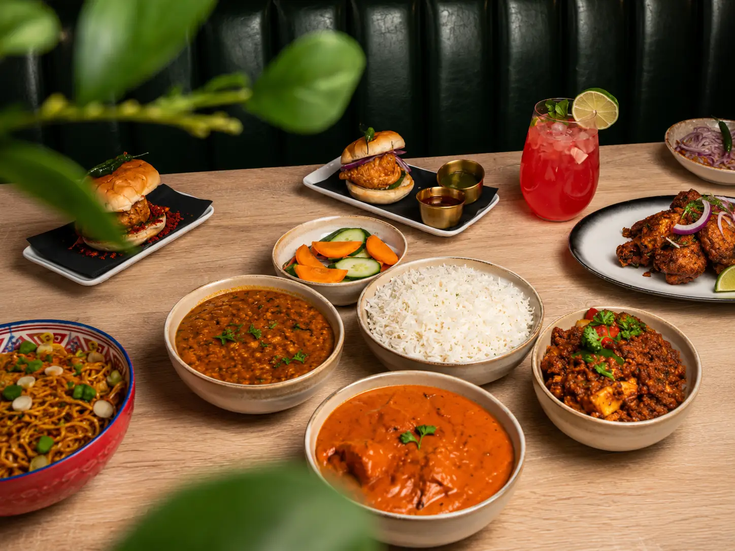 Large Indian feast featuring curries, naan, rice, and street food